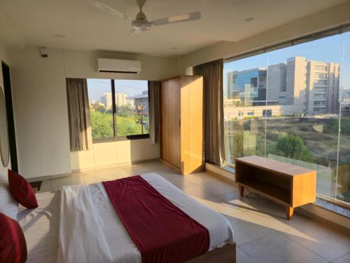 a bedroom with a bed and a large window at Gajraj Hotel in Vadodara