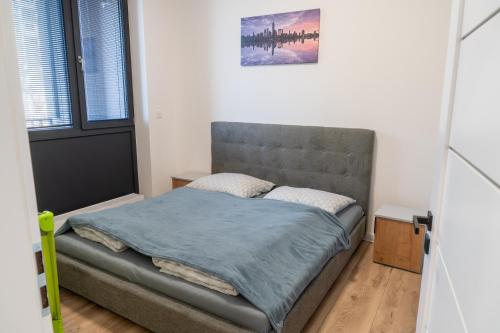 a bedroom with a bed with a blue blanket on it at Top Apartmán v Central Point Humenné M in Humenné