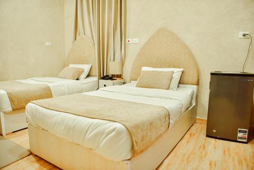 a hotel room with two beds and a television at LALA LAND Fayoum in Tunis