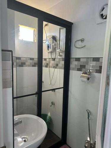 a bathroom with a shower and a sink at Little Miami Beach Resort in Anda