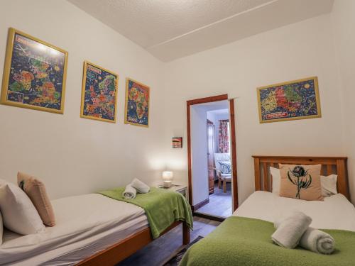 a bedroom with two beds and a mirror at Islay Cottage in Kincraig