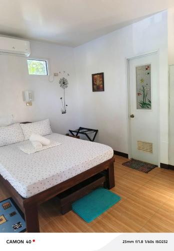 a bedroom with a bed and a door with a window at Little Miami Beach Resort in Anda