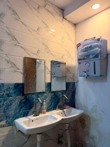 a bathroom with a sink and two mirrors at Cozy Inn Hostel in New Delhi