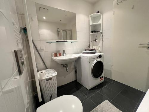 a bathroom with a washing machine and a sink at Apartment CentrumMitte Anger in Erfurt
