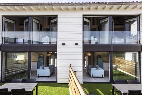 an external view of a building with tables and chairs at Apartamentos Catamarán Azul in Suances