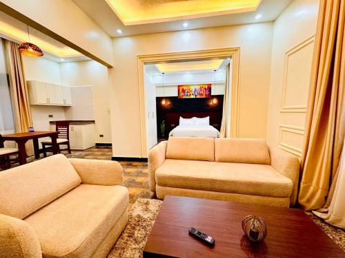 a living room with two couches and a bed at Pieme Hotel Residence in Migade
