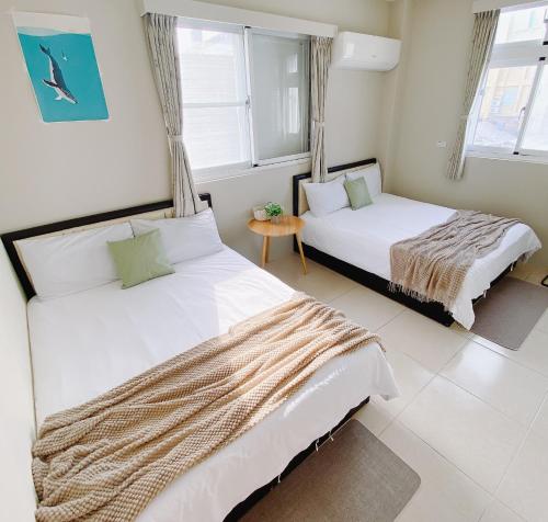 two beds in a room with two windows at 綠島夏御 微熱海岸 Coast Venus in Green Island