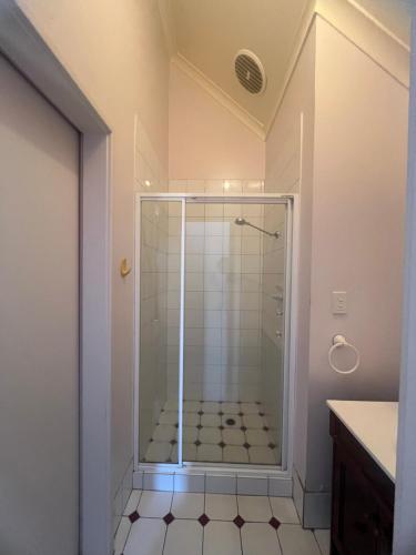 a shower with a glass door in a bathroom at Questro Lodge in Kalbarri