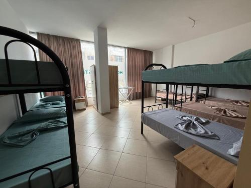 a room with three bunk beds in a building at Exeas Hostel in Vlorë
