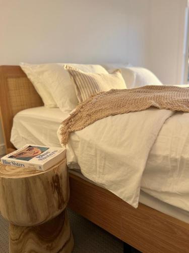 a bed with a wooden box next to it at Saltwater at Warilla Beach in Lake Illawarra