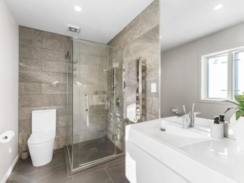 a bathroom with a toilet and a sink and a shower at Riverside Retreat with River views in Auckland