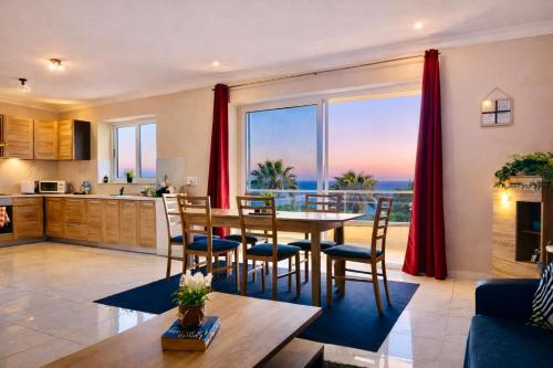 a kitchen and living room with a table and chairs at Sunrise Bay Apartments - Frontline Sea Views in St. Paul's Bay