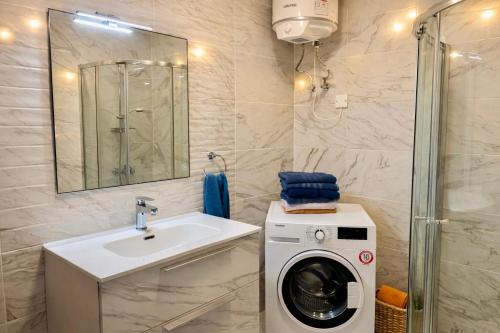a bathroom with a washing machine and a sink at Sunrise Bay Apartments - Frontline Sea Views in St. Paul's Bay