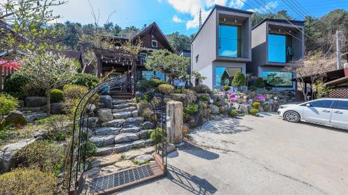 a house with a roller coaster in front of it at Fortune Rising Sun Hill Pension in Pocheon