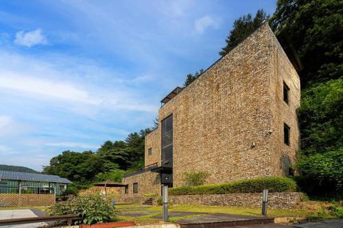 an old brick building with trees in the background at Yangpyeong Newspace in Yangpyeong