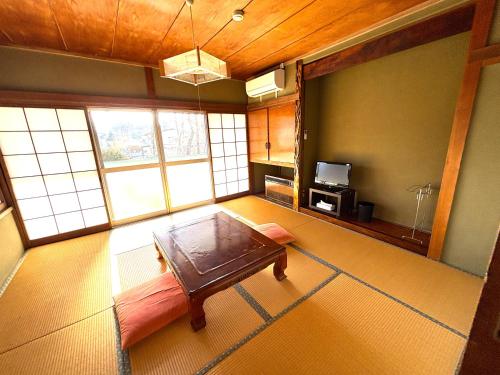 a room with a bed and a table in it at HOTEL MtFuji MOMO AUNG 桃庵 in Yamanakako