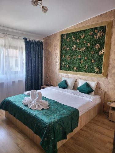 a bedroom with a bed with a painting on the wall at Casa Ratiu 3 Stele Airport Bucharest Therme Bucharest in Baloteşti