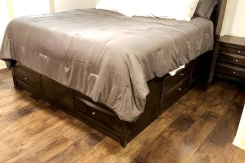 a bed in a bedroom with a wooden floor at Hot Tub 5 beds in Moorhead