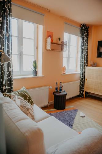 a living room with a couch and two windows at sleepArt cozy in Celle