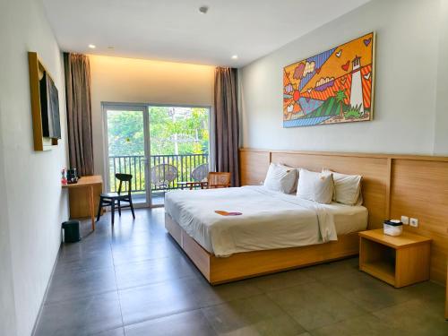 a hotel room with a bed and a balcony at The West Cove Hotel in Banten
