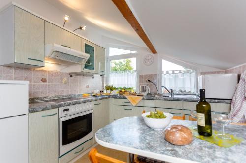 a kitchen with a counter with a bottle of wine at Apartments Villa Elizabet in Malinska