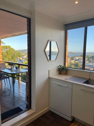a kitchen with a large window and a table with a view at Gosfords Best Location with Views in Gosford