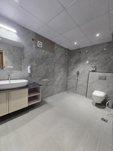 a bathroom with a sink and a toilet and a shower at HOTEL AYUSHMAN in Varanasi