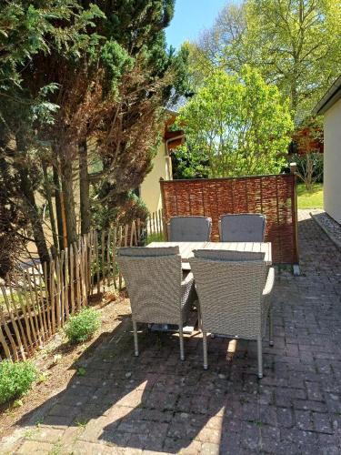 a table and chairs on a brick patio at Gemütliches Häuschen am Fleesensee in Göhren-Lebbin