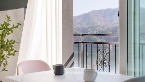 a balcony with a table and chairs and a view of a mountain at Gapyeong Zav Pool Villa in Gapyeong