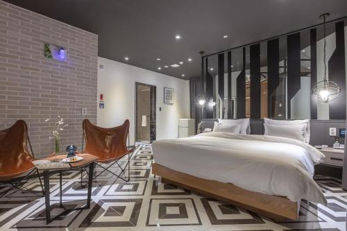 a bedroom with a large bed and a table and chairs at Gimhae Eobang-Dong Nomad Hotel in Gimhae