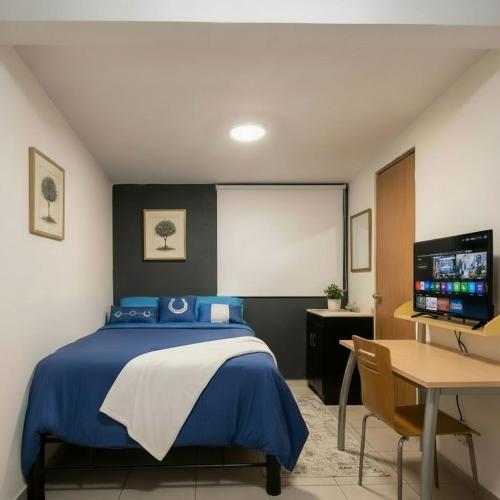 a bedroom with a bed and a desk and a screen at Casa providencia suites in Guadalajara