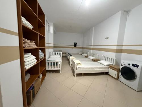 a room with a row of beds and a washing machine at Exeas Hostel in Vlorë