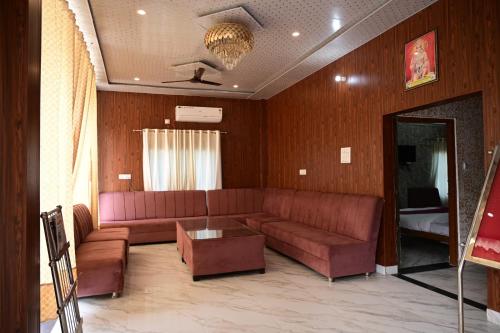 a living room with a couch and a table at Maa Mandakini Resort & Hotel in Chitrakoot