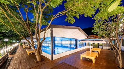 a deck with benches and a swimming pool at night at Glamdog - Tongyeong Pet-friendly in Tongyeong