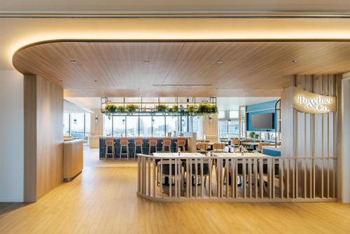 a lobby of a restaurant with a bar and chairs at Hilton Garden Inn Yokohama Minatomirai in Yokohama