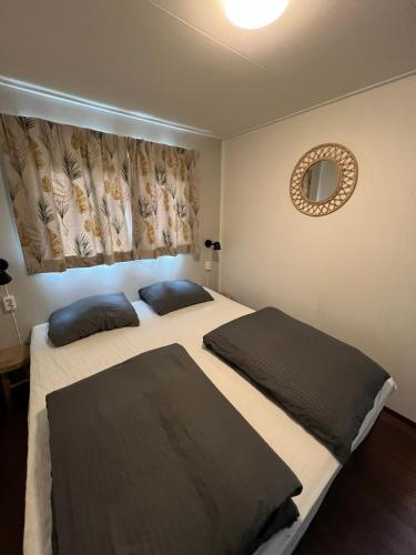 two beds in a small room with a mirror and a mirror at Wellness in de NATUUR in Neede