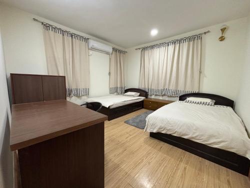 a hotel room with two beds and a desk at L&S apartment in Kathmandu
