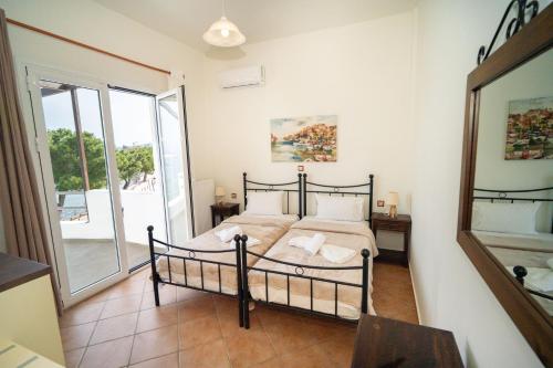 a bedroom with a bed and a large window at ARTEMIS ROOMS in Pefki