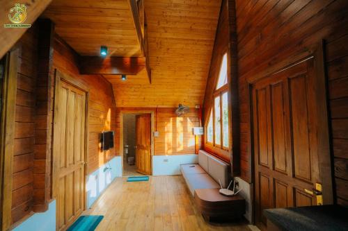 a hallway of a wooden cabin with a bench and a door at Ume Villa & Retreat in Bóng Suối