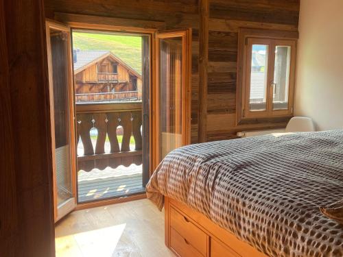 a bedroom with a bed and a large window at Chalet Les Ravaires, Morgins in Troistorrents