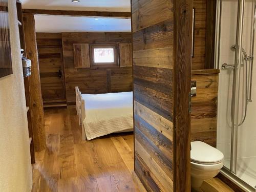 a bathroom with a toilet and a bed in a room at Chalet Les Ravaires, Morgins in Troistorrents