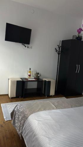 a bedroom with a bed and a tv and a table at Pensiunea Izabel in Lacu Rosu