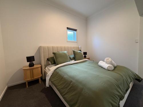 a bedroom with a large green bed with a window at The Nook in Greytown