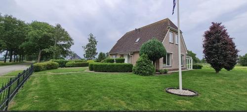 a house with a flag pole in the yard at Romsicht in Siegerswoude