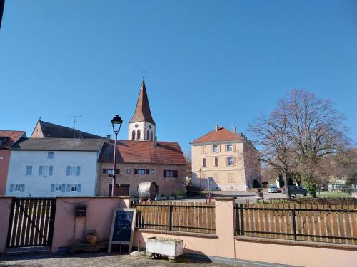 a view of a town with a church and a fence at Gîte d'ammerschwihr in Ammerschwihr