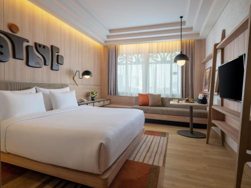 a hotel room with a bed and a couch at Grand Inna Tunjungan Hotel Surabaya in Surabaya