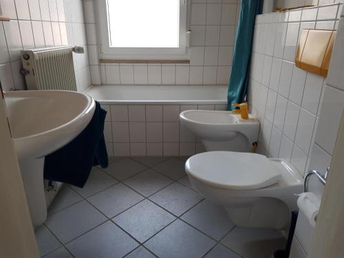 a bathroom with a sink and a toilet and a tub at Ferienwohnung Martino in Simmern