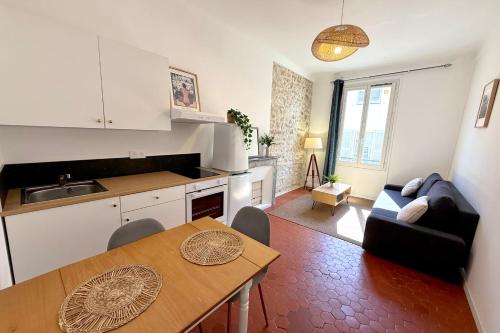 a kitchen and living room with a table and a couch at Old Antibes 1 Bedroom 4 Persons in Antibes