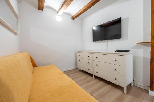 a living room with a couch and a tv and a dresser at Hauzify I Domus Tarragona in Tarragona