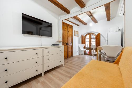 a living room with a white dresser and a tv at Hauzify I Domus Tarragona in Tarragona